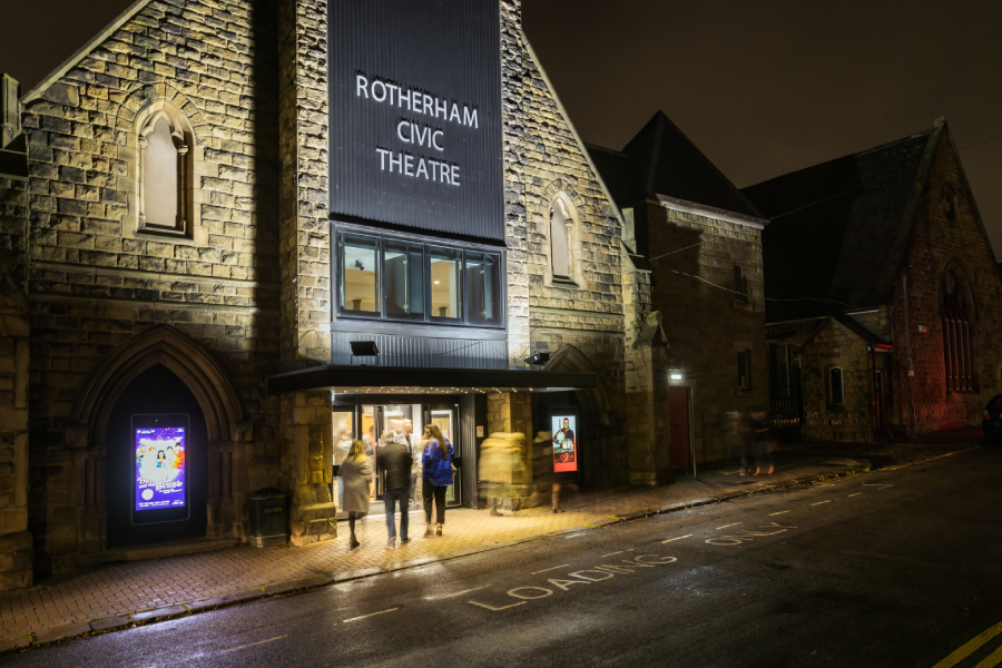 Rotherham Civic Theatre at night with theatregoers at the main entrance