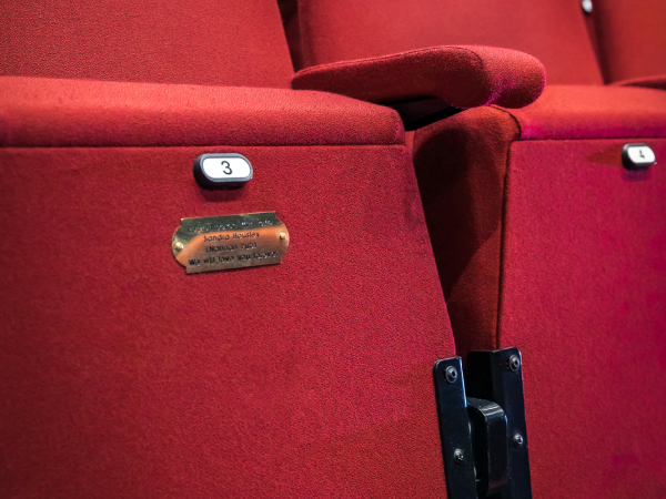 Close-up of engraved plaque on theatre seat